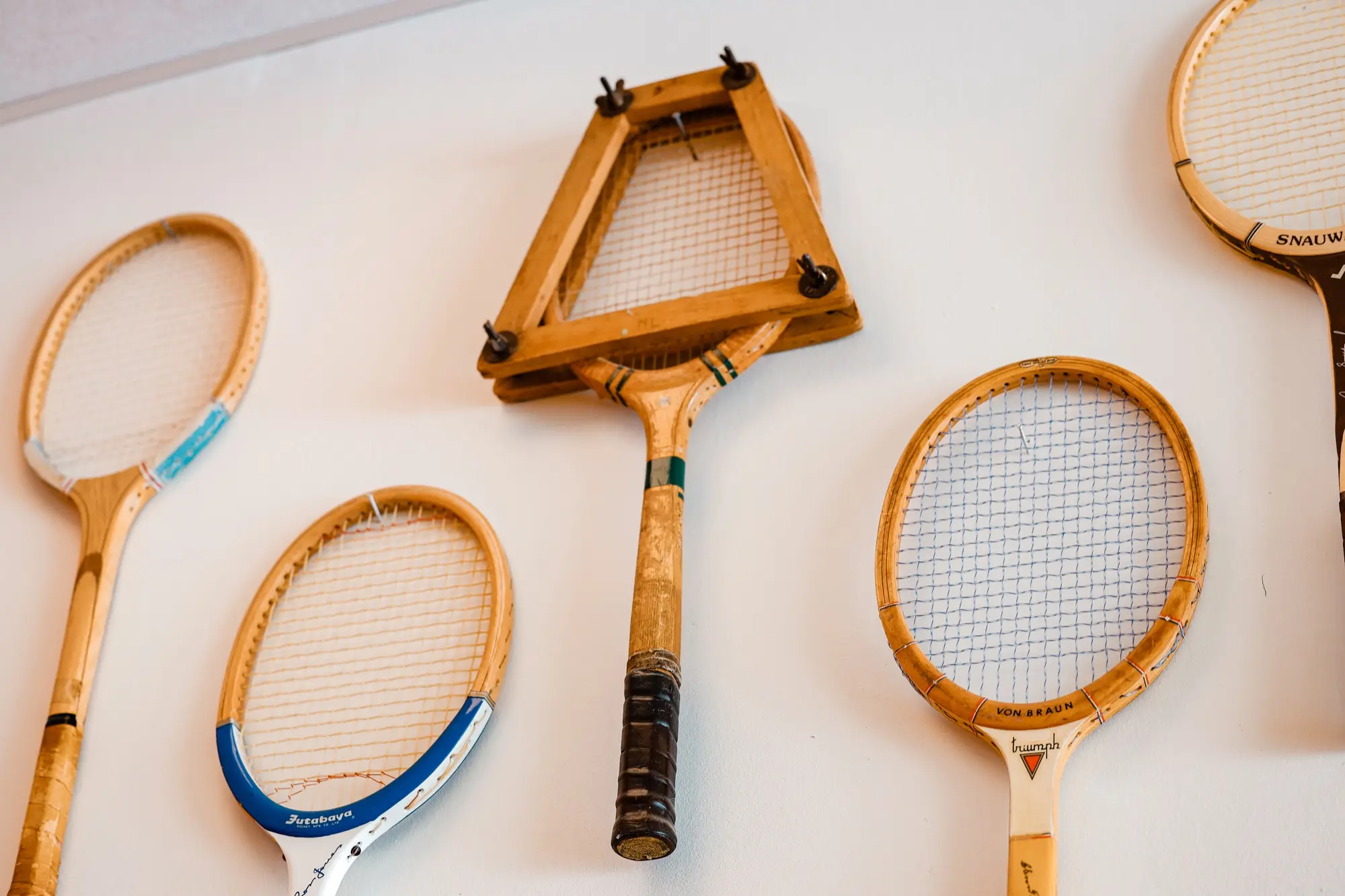 Vägg med gamla träracketar från Futabaya, Von Braun och Snauwaert